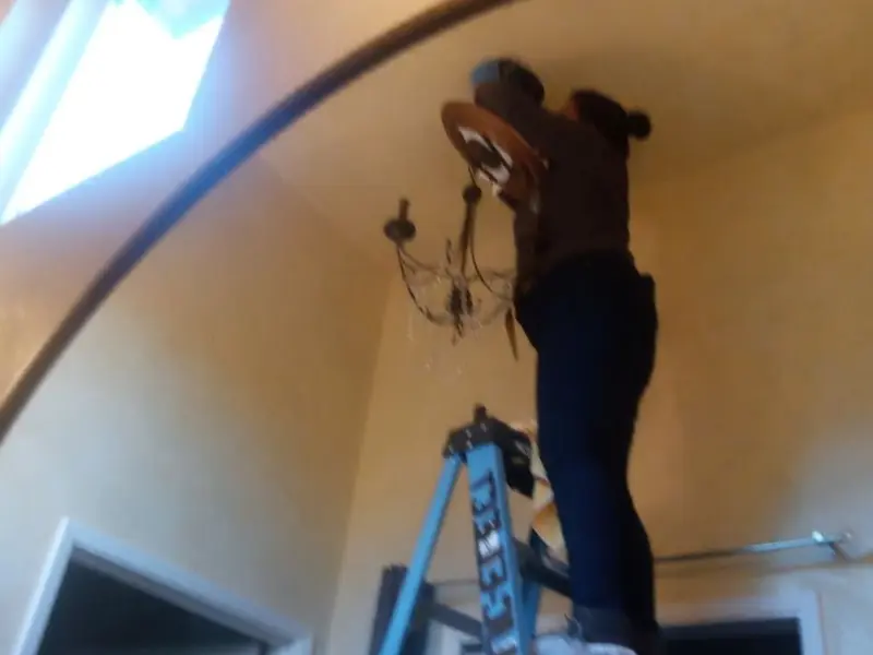 Electrician installing a chandelier in a Whitehouse residence